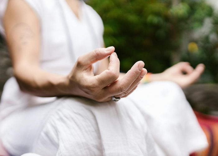 Peaceful person meditating with hands in mudra position